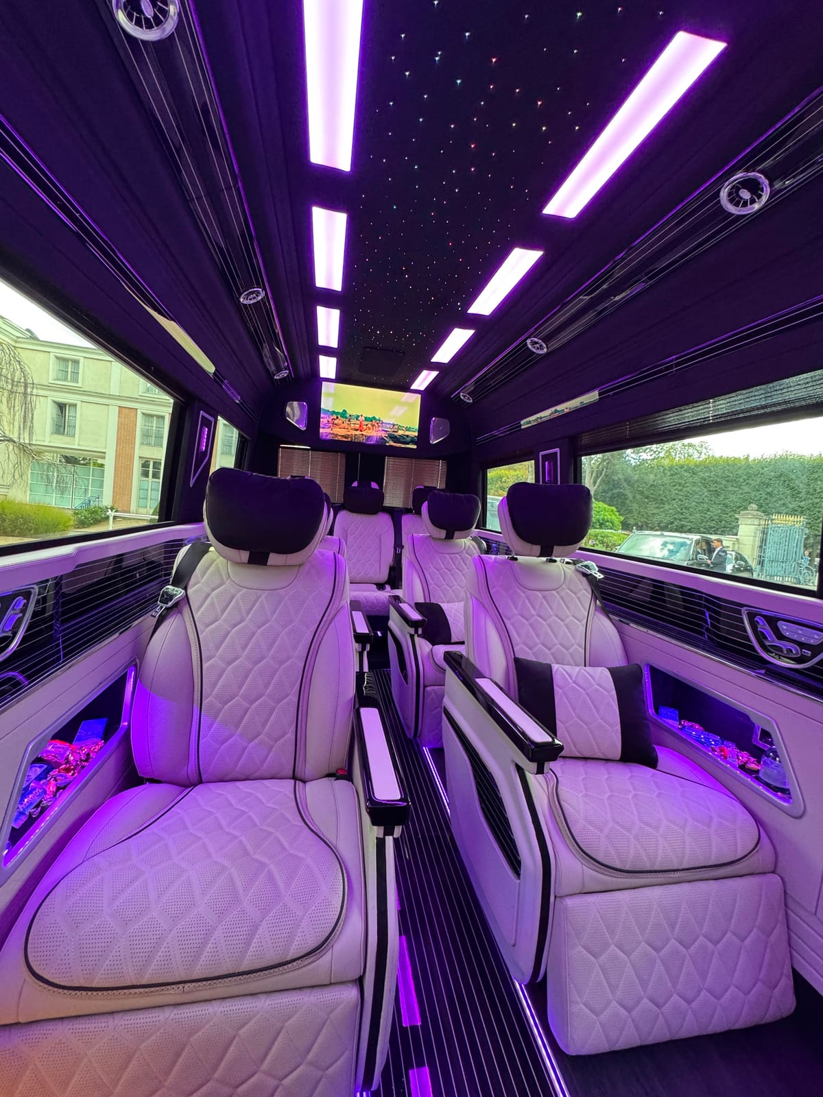 Sprinter VIP Paris — fauteuils capitaine cuir blanc capitonné sous ambiance LED violette, salon privatisé pour tournées